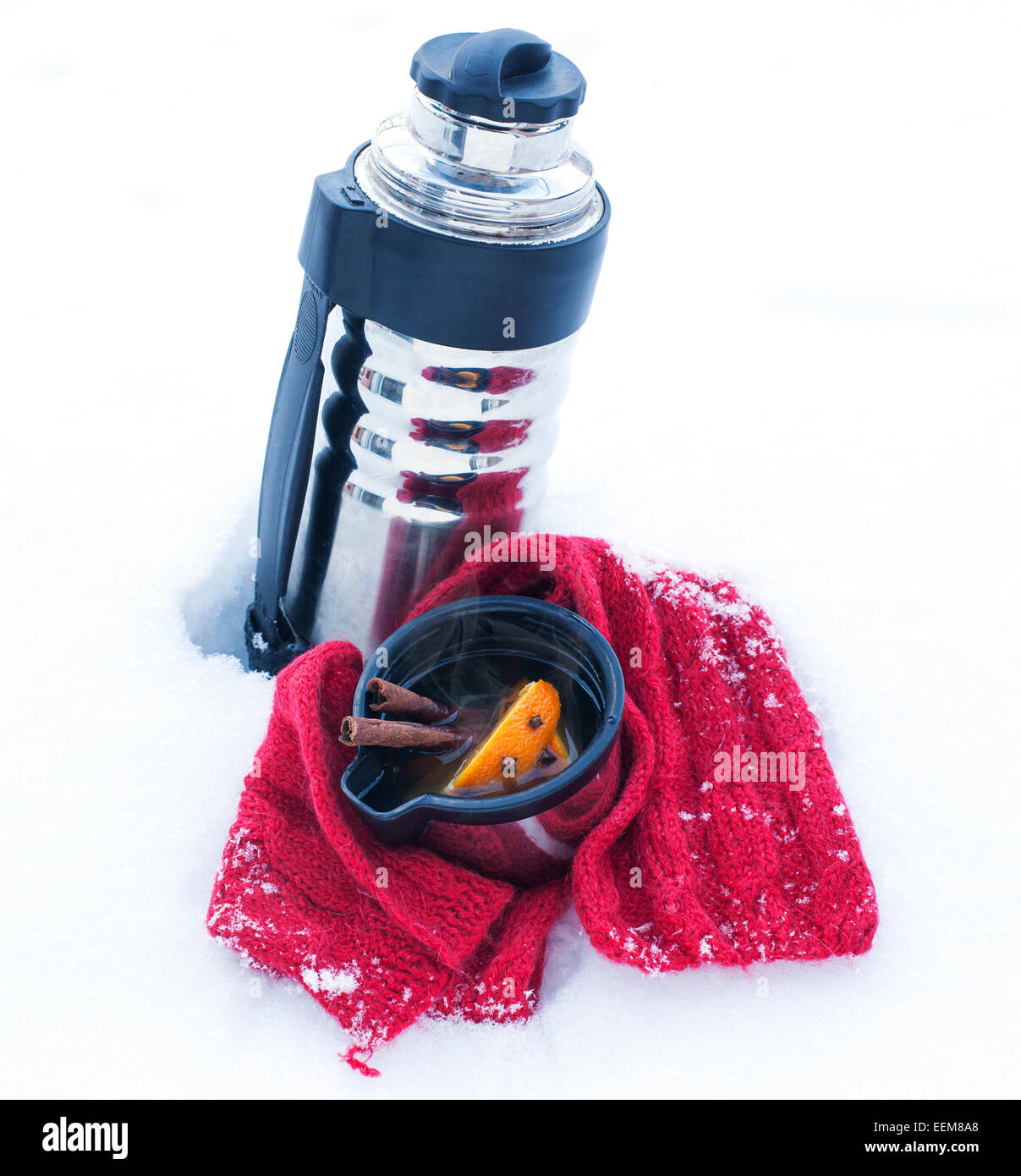 Tasse Glühwein, Thermoskanne und Schal auf Schnee Stockfotografie - Alamy