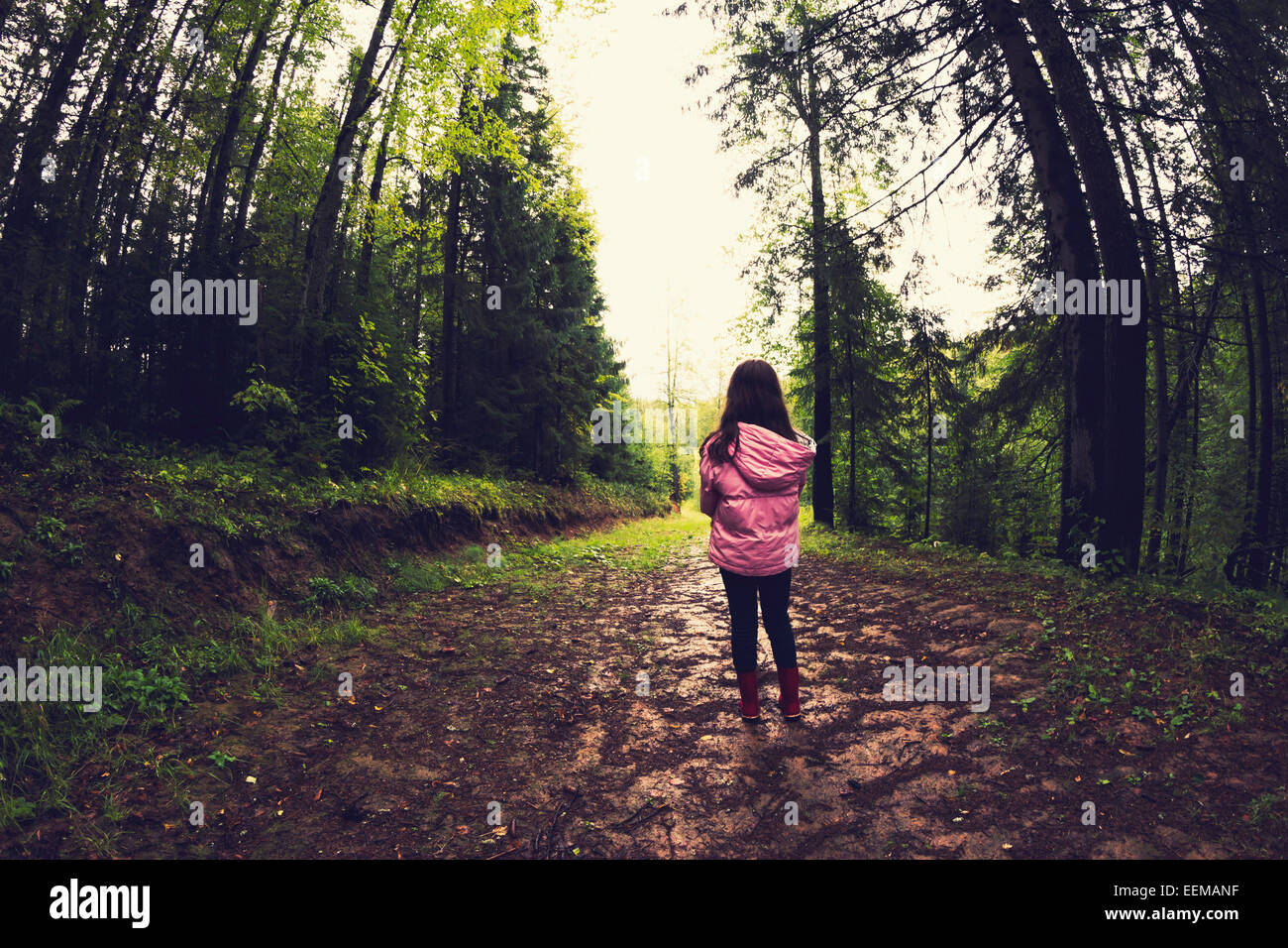 Kaukasische Mädchen zu Fuß auf unbefestigten Weg im Wald Stockfoto