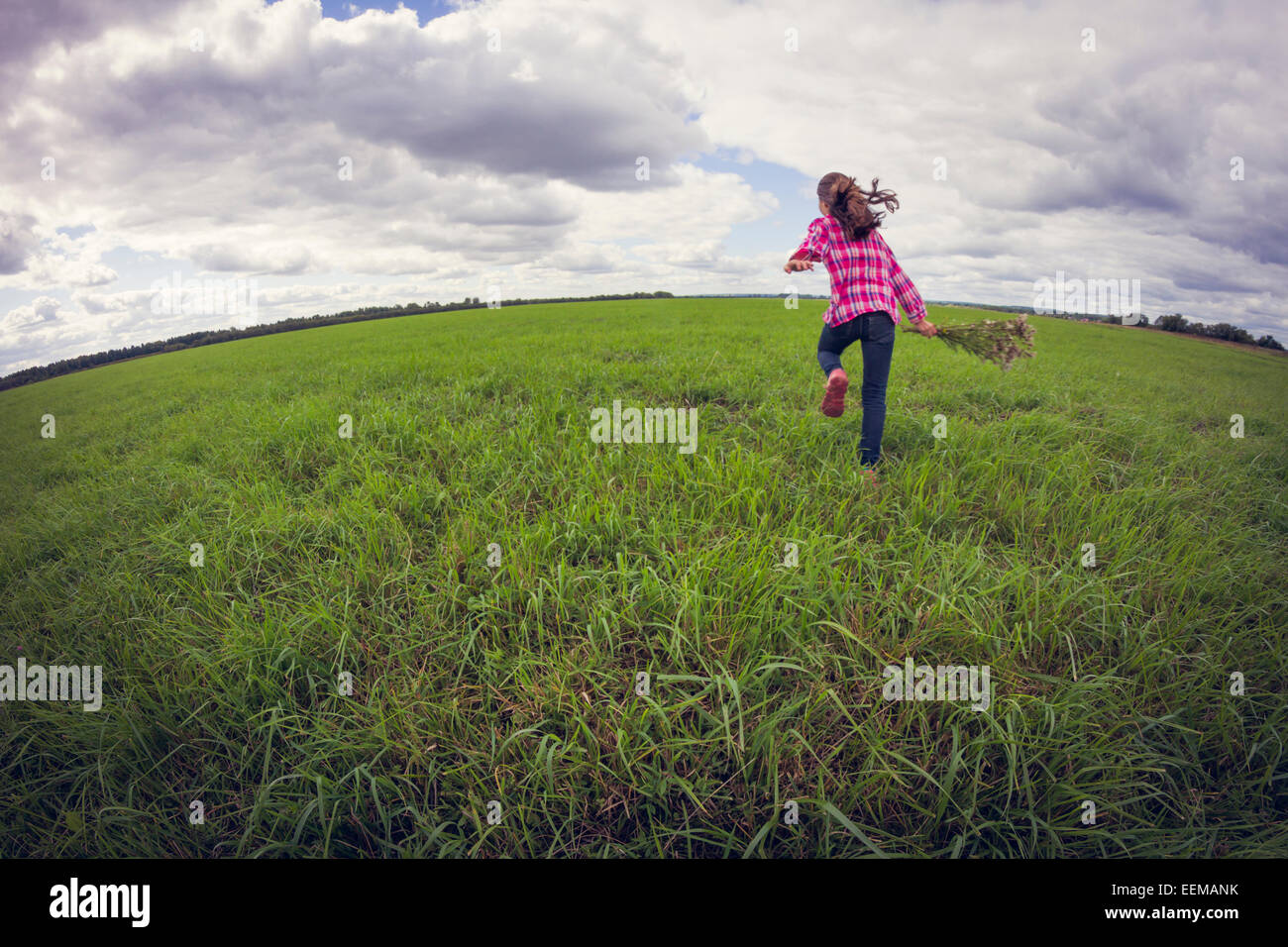 Kaukasische Mädchen laufen auf Wiese Stockfoto