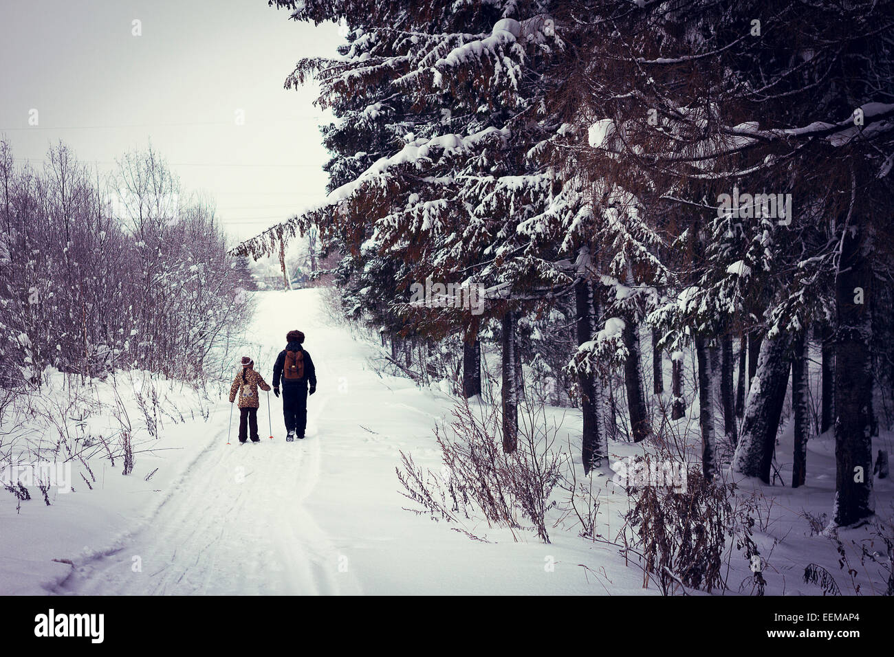 Kaukasische Vater und Tochter Langlaufen auf verschneiten Straße Stockfoto