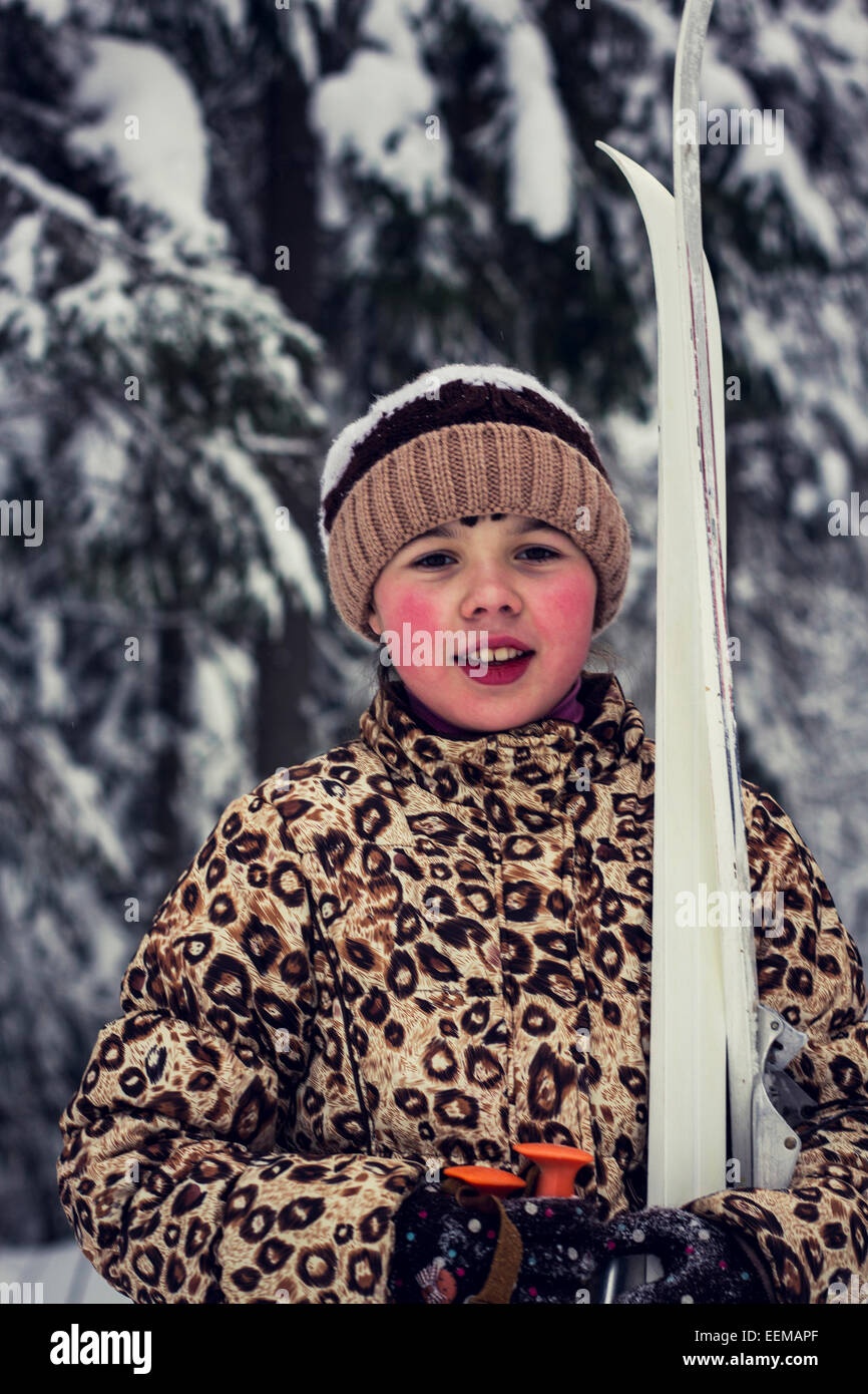Kaukasische Mädchen tragen Skier im Wald Stockfoto