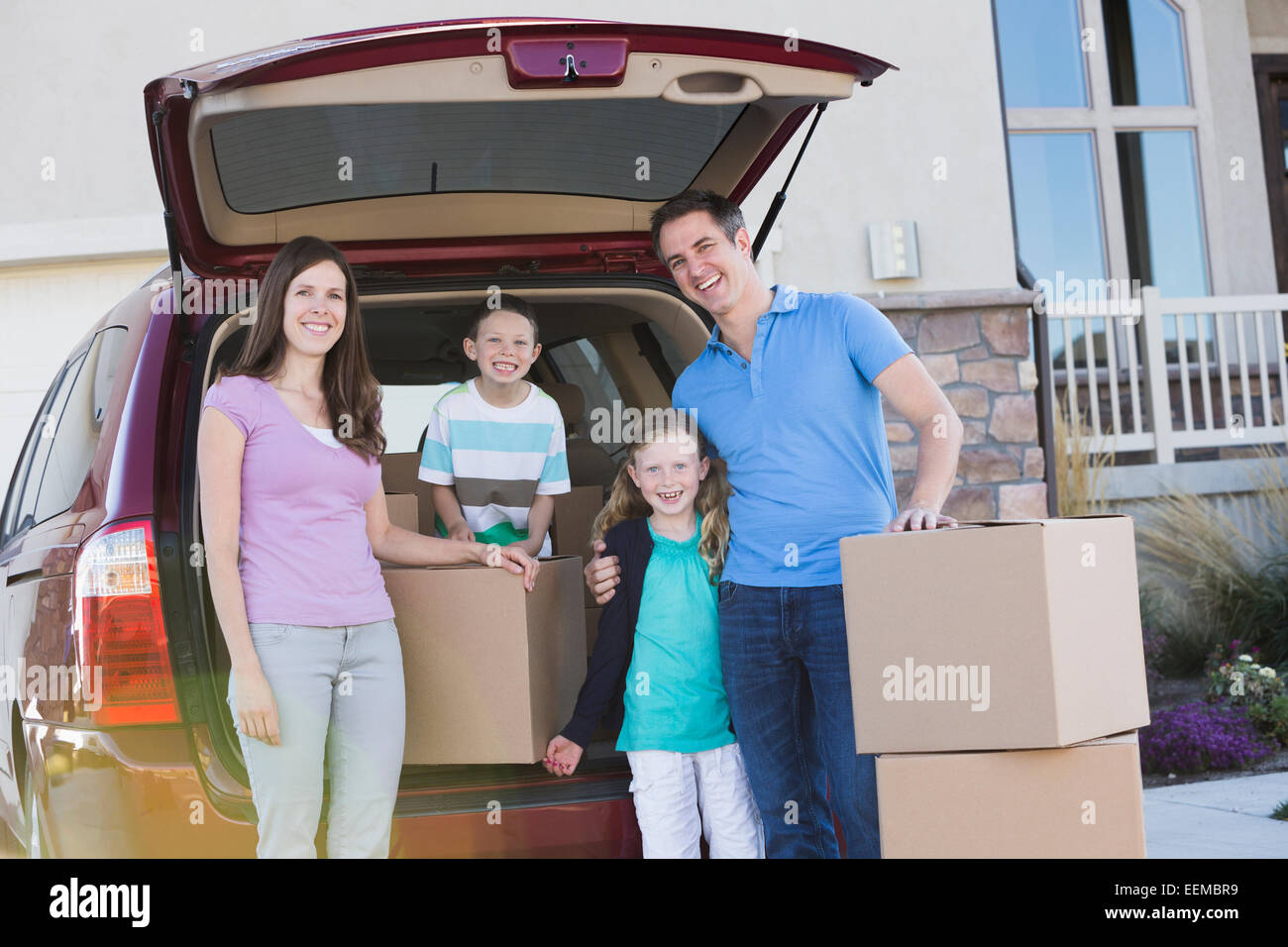 Kaukasische Familie Auspacken Karton Kisten aus dem Auto Stockfoto