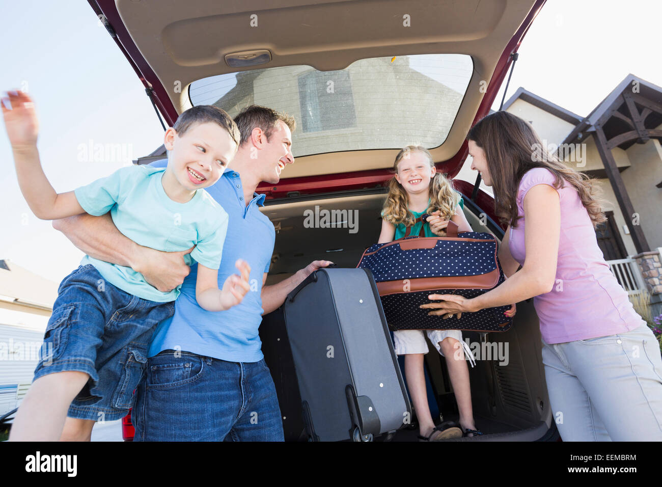 Kaukasische Familie Auspacken Koffer aus dem Auto Stockfoto