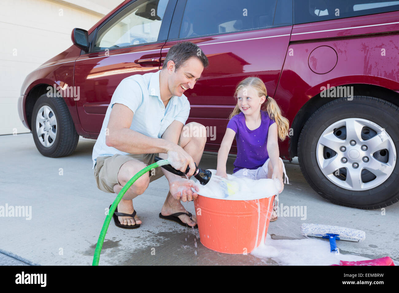 Kaukasische Vater und Tochter Waschen Auto in der Einfahrt Stockfoto