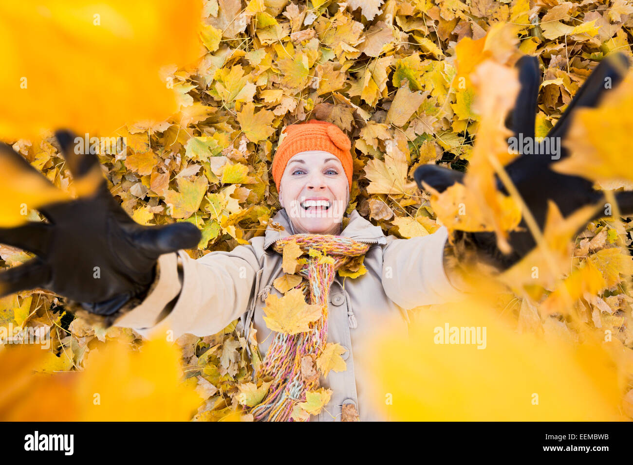 Ältere Frau kaukasischen spielen im Herbstlaub Stockfoto