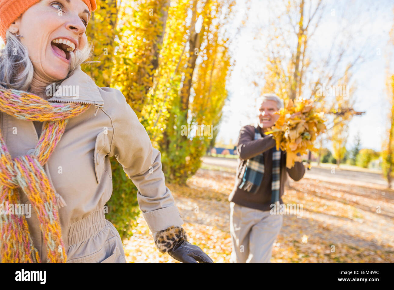 Ältere kaukasischen paar spielen mit Herbstlaub Stockfoto