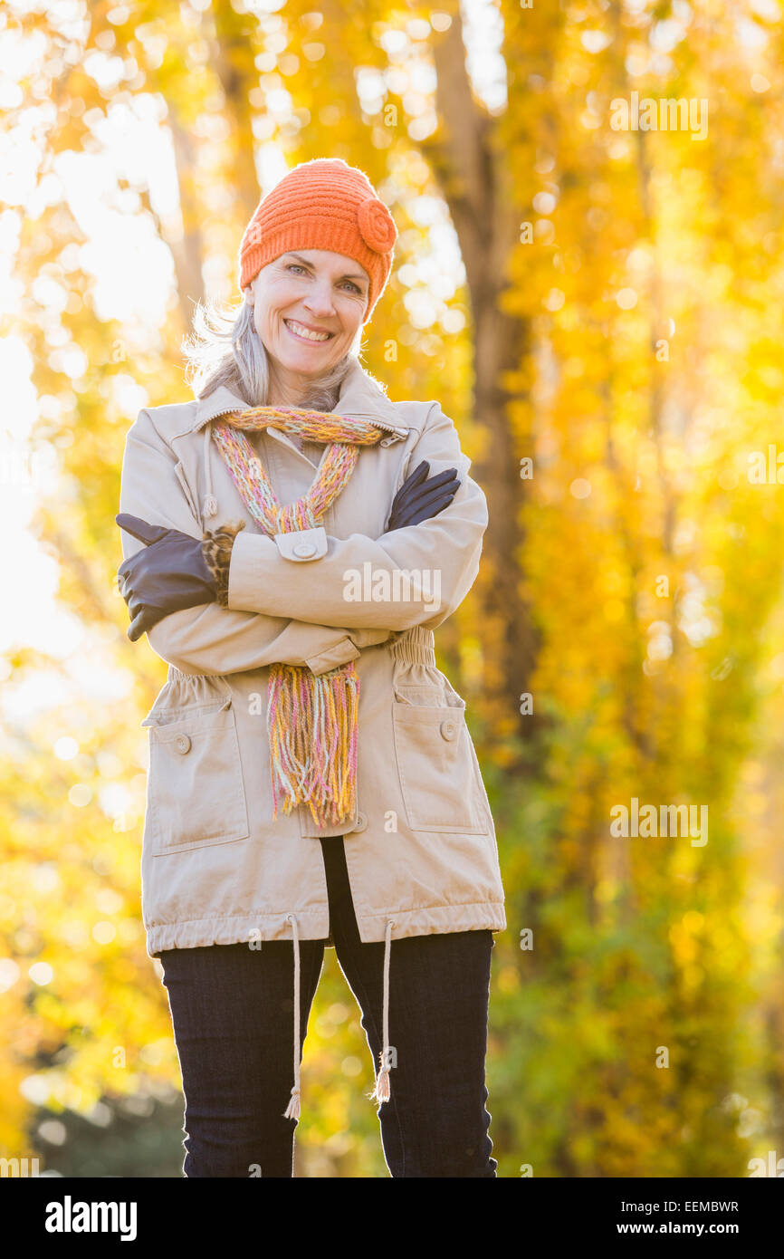 Ältere Frau kaukasischen lächelnd in der Nähe von Herbst Bäume Stockfoto