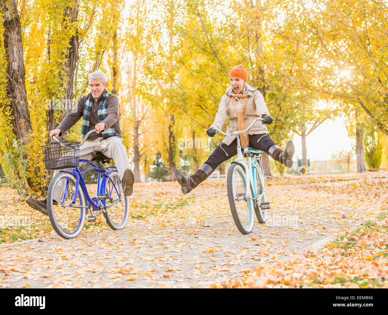Ältere kaukasischen paar Fahrrad auf Blätter im Herbst Stockfoto