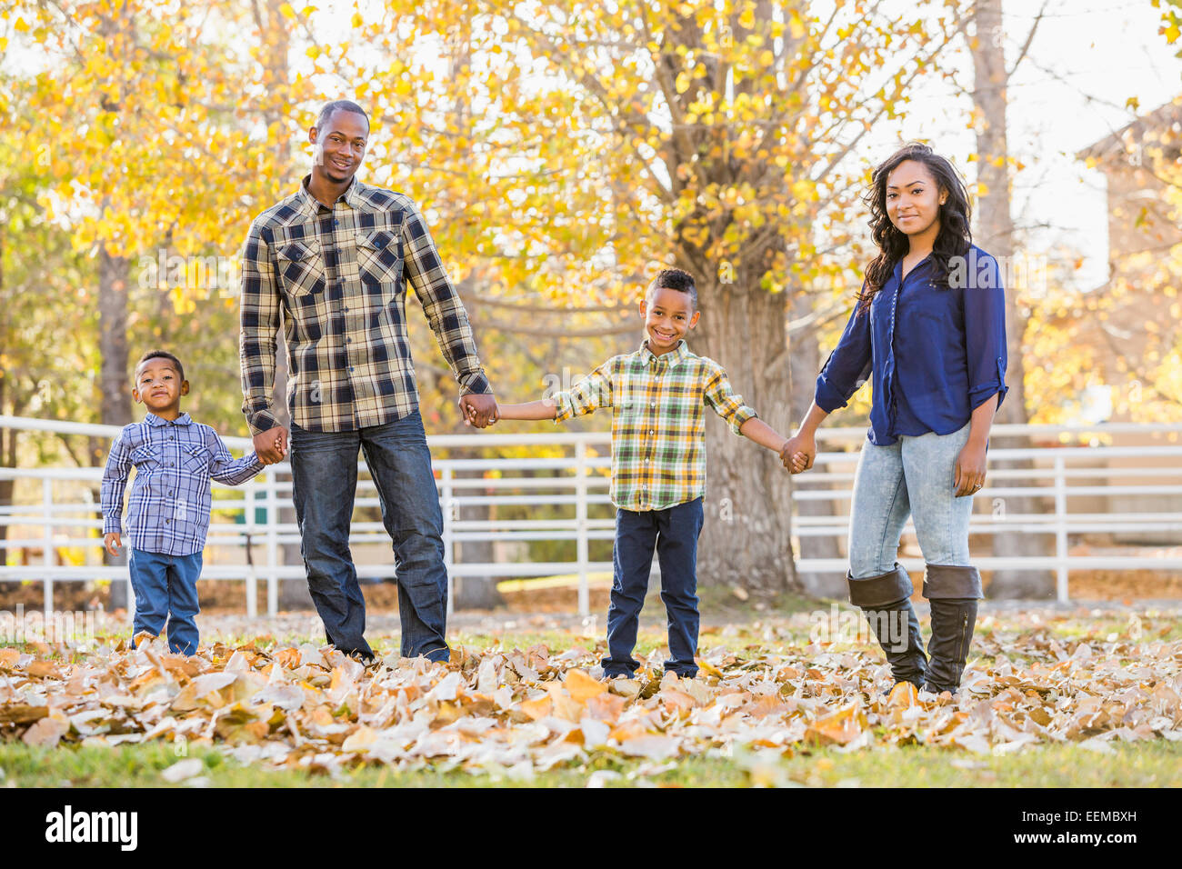 Familie Hand in Hand im Herbstlaub Stockfoto