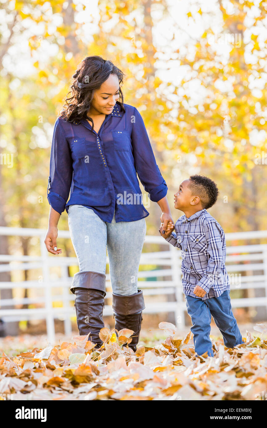 Schwarzen Mutter und Sohn Hand in Hand im Herbstlaub Stockfoto