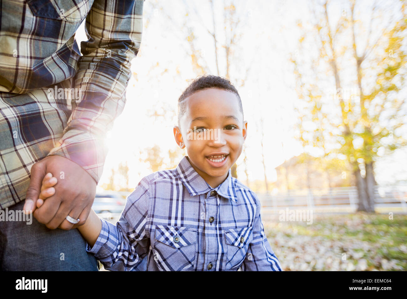 Schwarze Vater und Sohn wandern im Herbstlaub Stockfoto