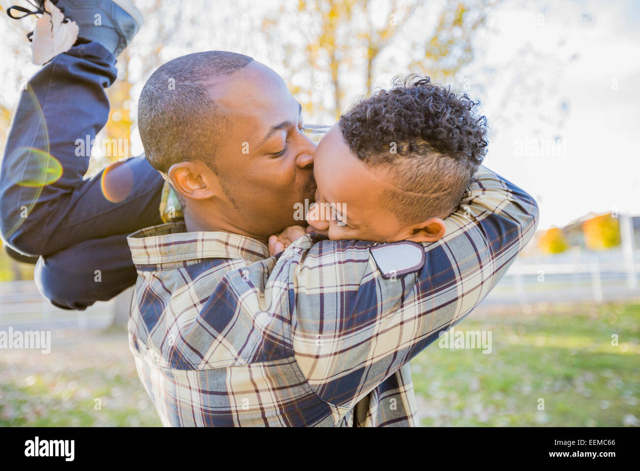 Vater küssen Sohn im freien Stockfoto