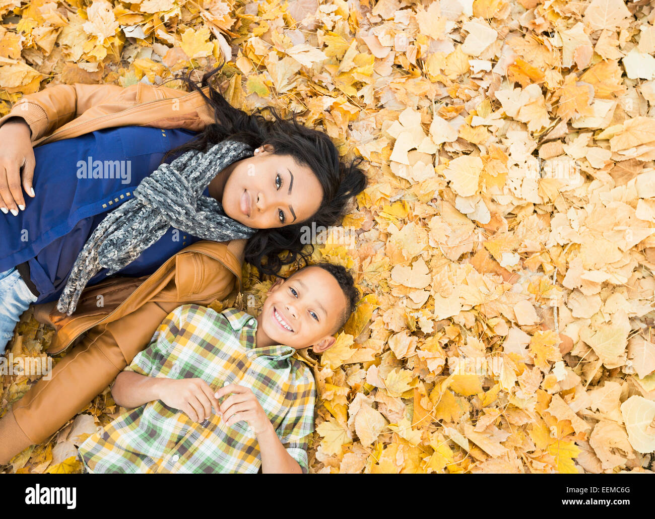 Mutter und Sohn zusammen im Herbstlaub Verlegung Stockfoto