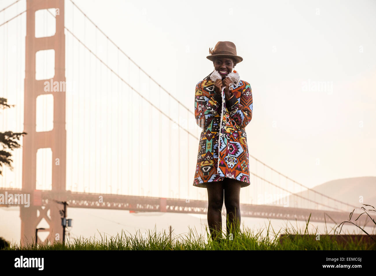 Schwarze Frau mit bunten Mantel von Golden Gate Bridge, San Francisco, California, Vereinigte Staaten von Amerika Stockfoto