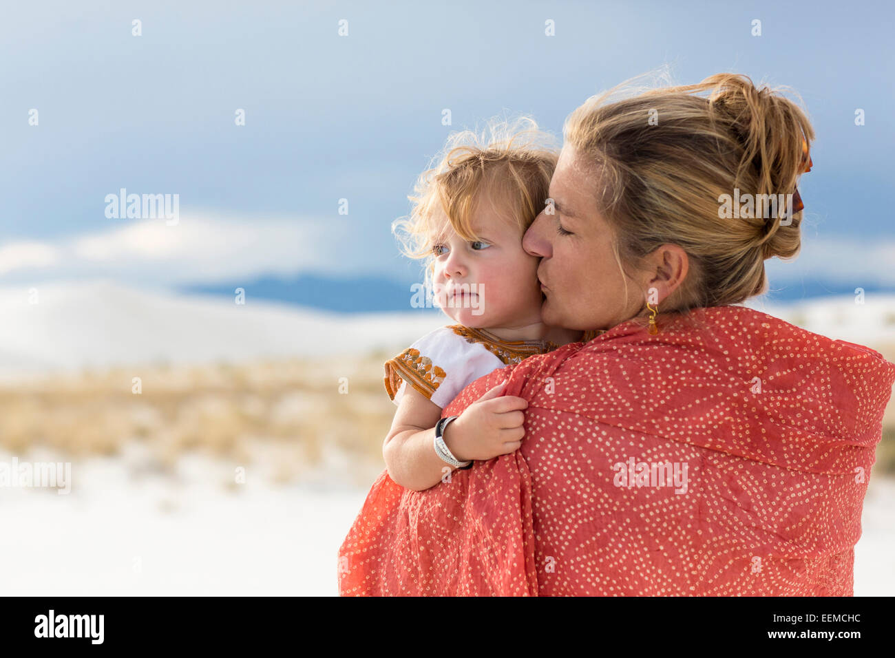 Kaukasische Mutter und Sohn in Decke auf Sanddüne gewickelt Stockfoto