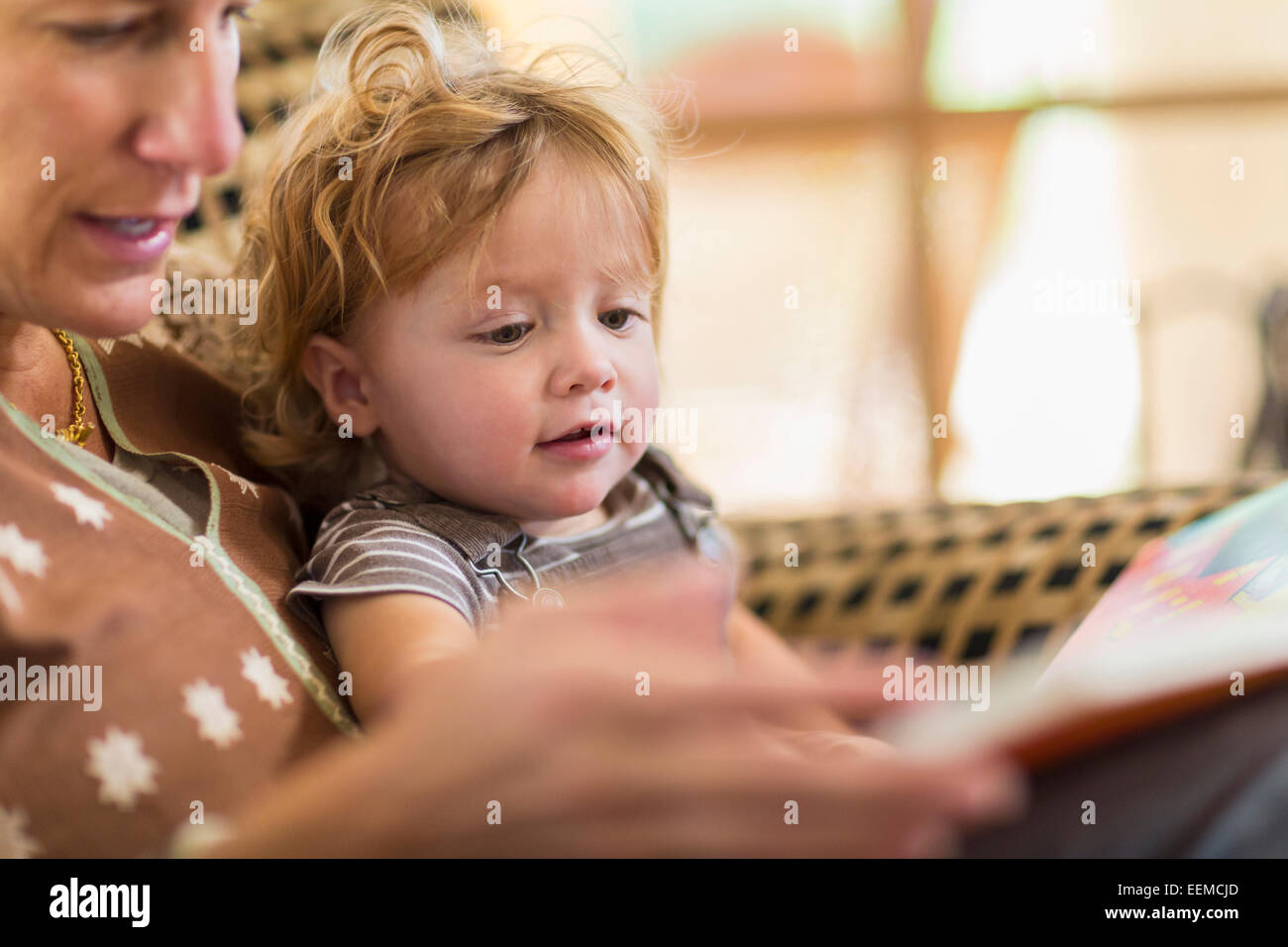 Kaukasische Mutter Sohn im Sessel lesen Stockfoto