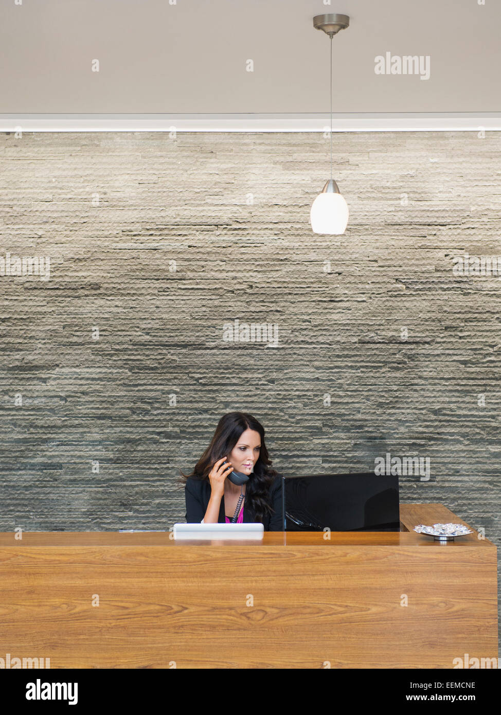 Kaukasische Empfangsdame an der Rezeption Büro arbeiten Stockfoto