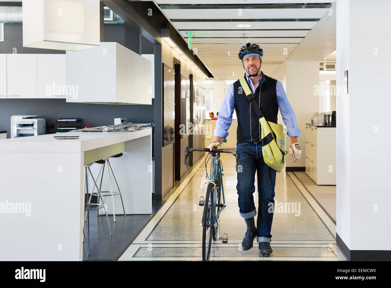 Kaukasische Geschäftsmann mit dem Fahrrad im Büro Stockfoto