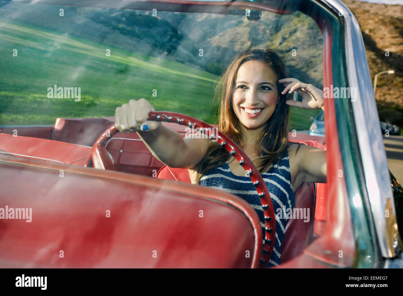 Hispanische Autofahrerin im klassischen Cabrio Stockfoto