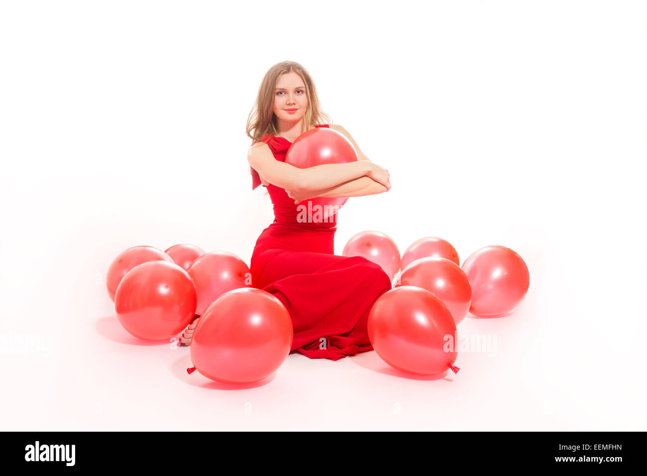 junge Frau mit roten Luftballons auf weißem Hintergrund spielen Stockfoto