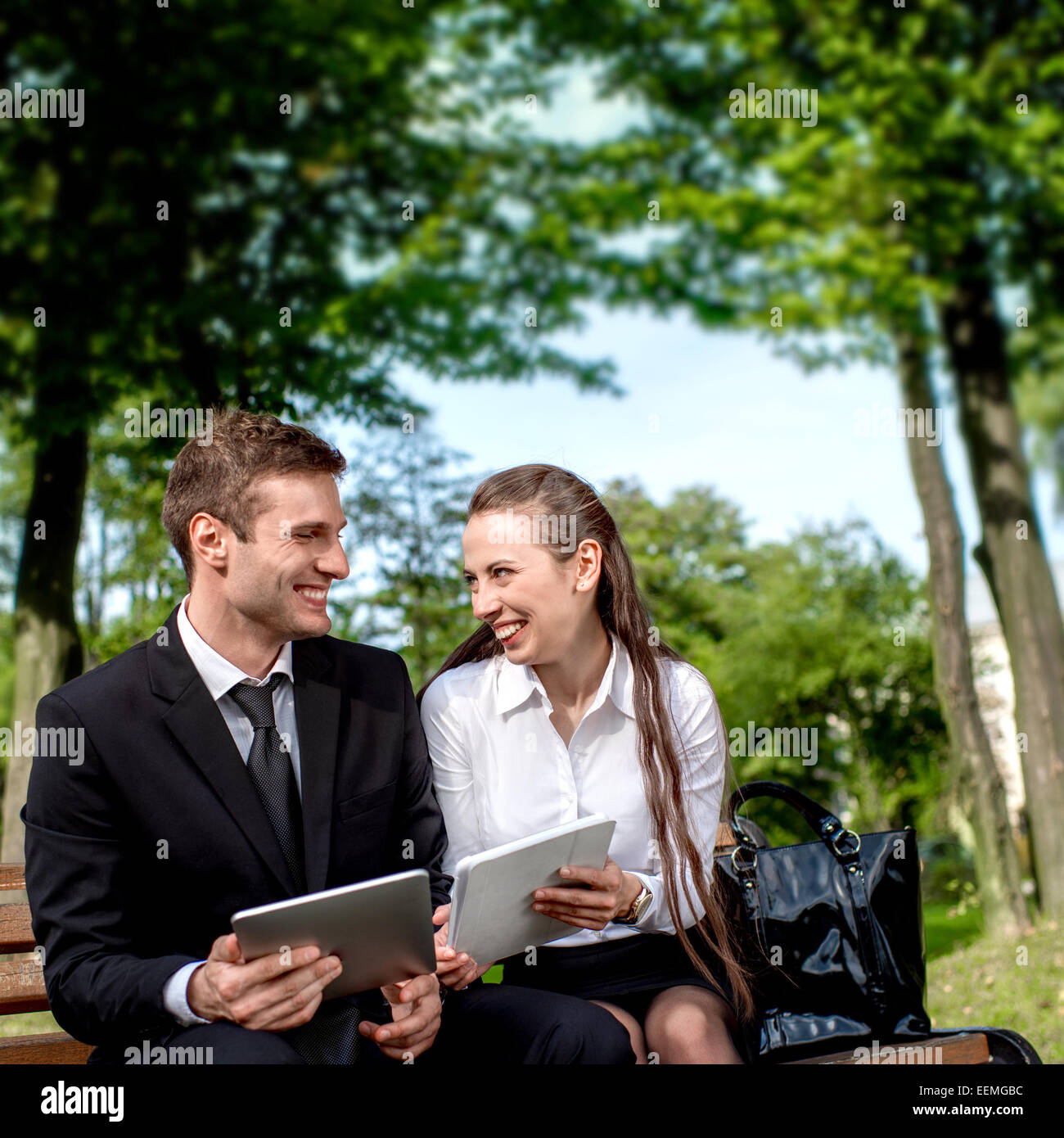 Young Business paar auf der Bank sitzen und machen Selfie Foto mit Tabletten Stockfoto