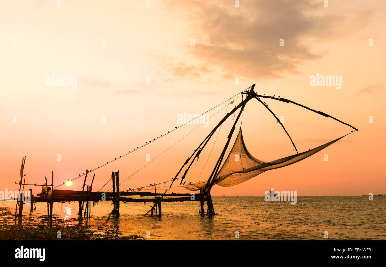 Ein chinesisches Fischernetz in Ruhe den Sonnenuntergang über dem arabischen Meer in Fort Kochi, Kerala, Indien. Stockfoto
