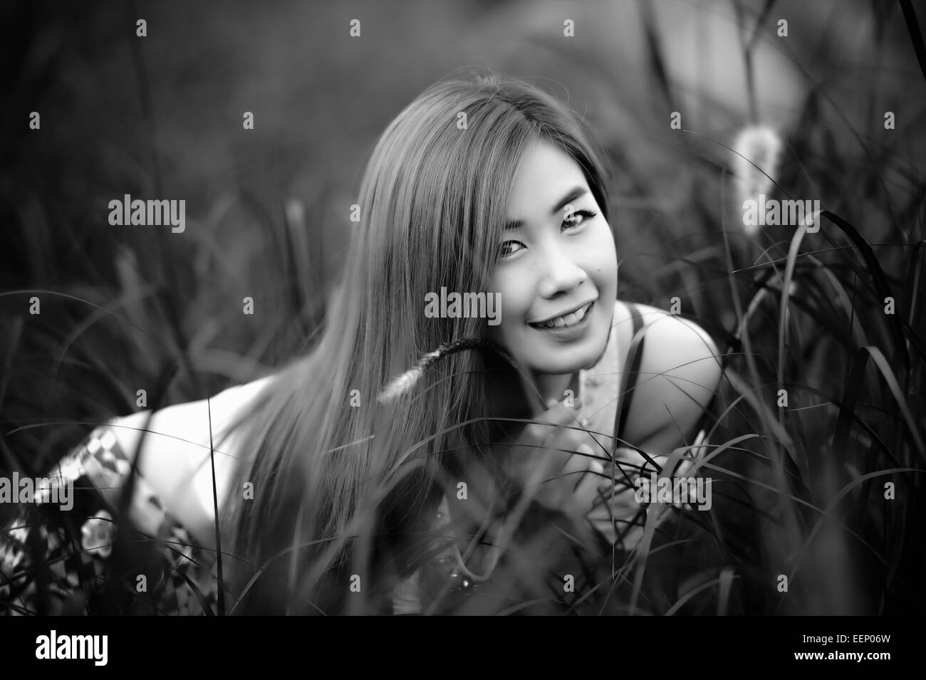 schwarz / weißes Porträt Thai schöne Mädchen sitzen auf dem Rasen Stockfoto