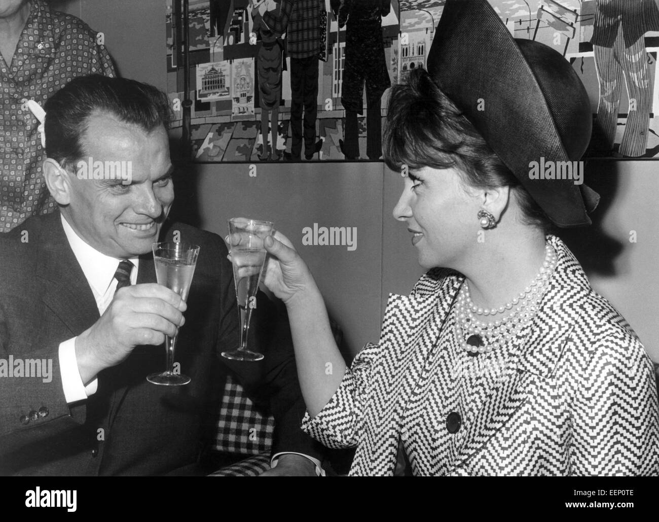 Dirigent Afred Bauer begrüßt die italienische Schauspielerin Gina Lollobrigida nach ihrer Ankunft am Flughafen Tegel in Berlin am 2. Juli 1965 mit einem Glas Sekt. Stockfoto