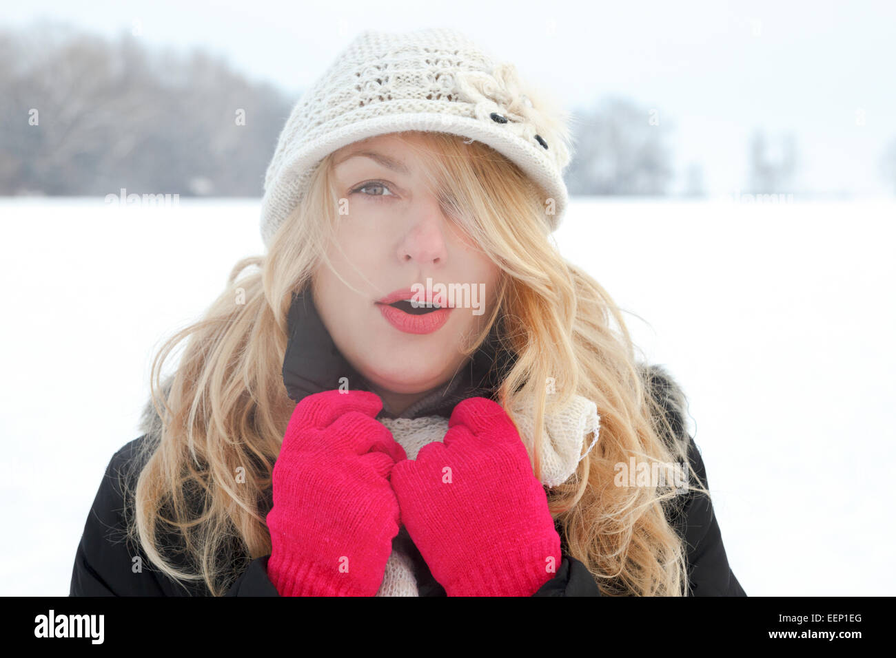Winter-Frau im Schnee Foto, auf der Suche und Schläge Atem in die Kamera draußen an kalten Wintertag. Porträt-kaukasischen weibliches Modell mit Stockfoto