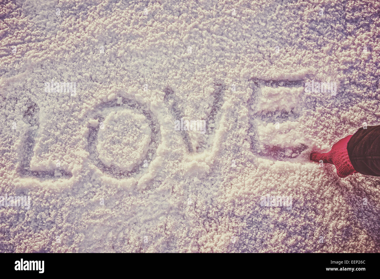 schriftliche oder per hand gezeichnet, in rosa Handschuh Wort Liebe auf weißen Schnee, romantische Bildkomposition, Vintage Foto. Menschliche Hand schreiben oder d Stockfoto