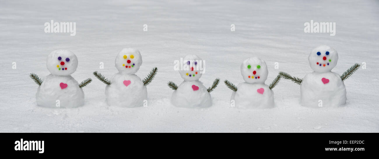 Fünf bunte Schneemänner mit großem Herz. Panorama Stockfoto