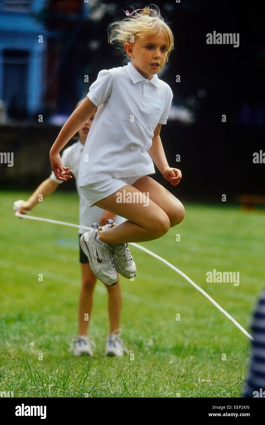 Ein junges Mädchen Seilspringen auf ein Schulsporttag. England. UK Stockfoto