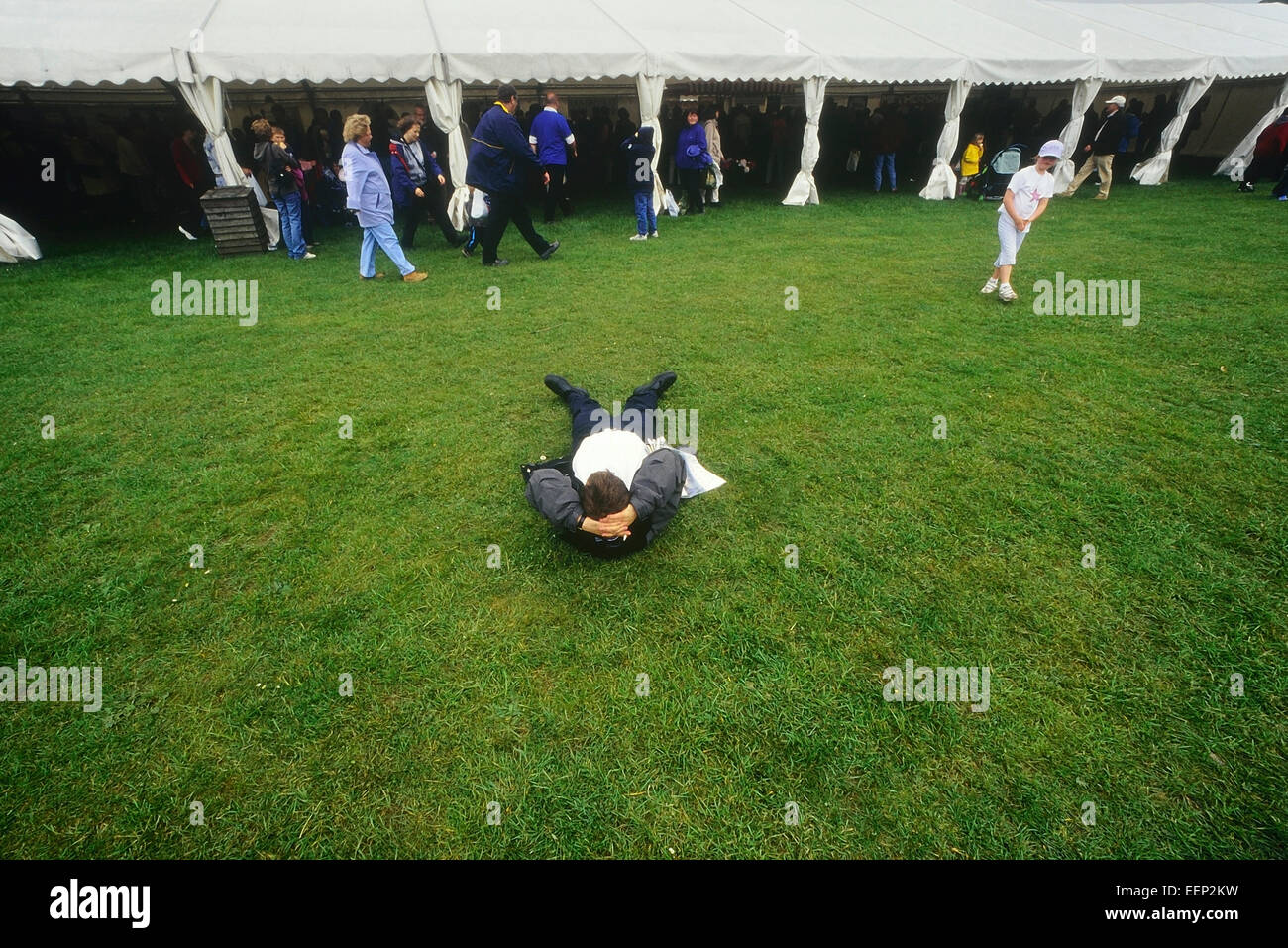 Ein Mann, der sich auf dem Gras an einem Food Festival in Leeds Castle. Kent, Großbritannien 1980 Stockfoto
