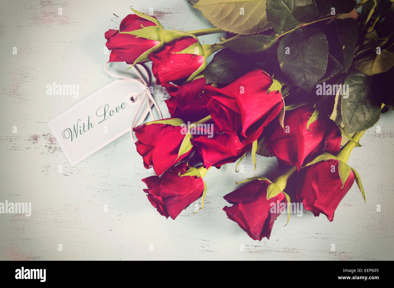 Retro-Filter Vintage rote Rosen Geschenk für Valentinstag, recycelt Geburtstag oder besonderen Anlass auf blasse Aquablau notleidenden Holz Stockfoto
