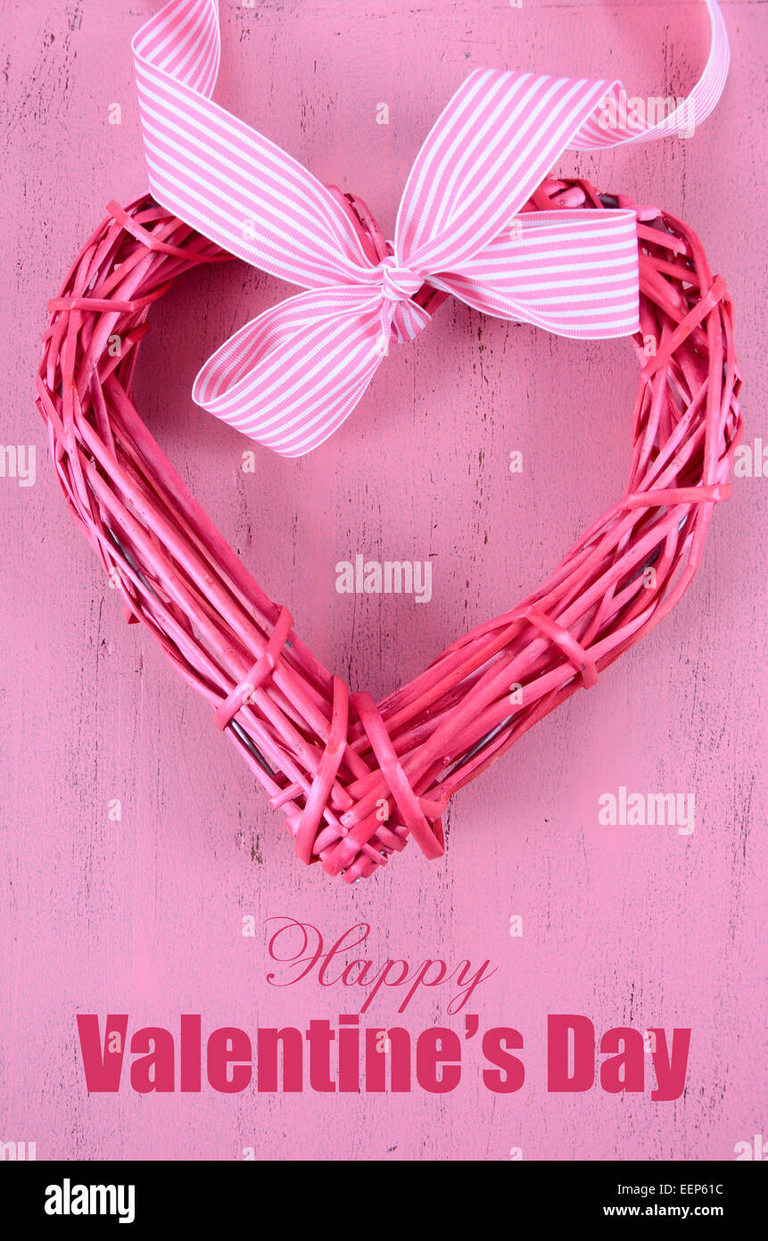 Happy Valentinstag rosa Stock Kranz mit Streifen Band auf shabby chic rosa Holz Hintergrund mit Beispieltext... Stockfoto