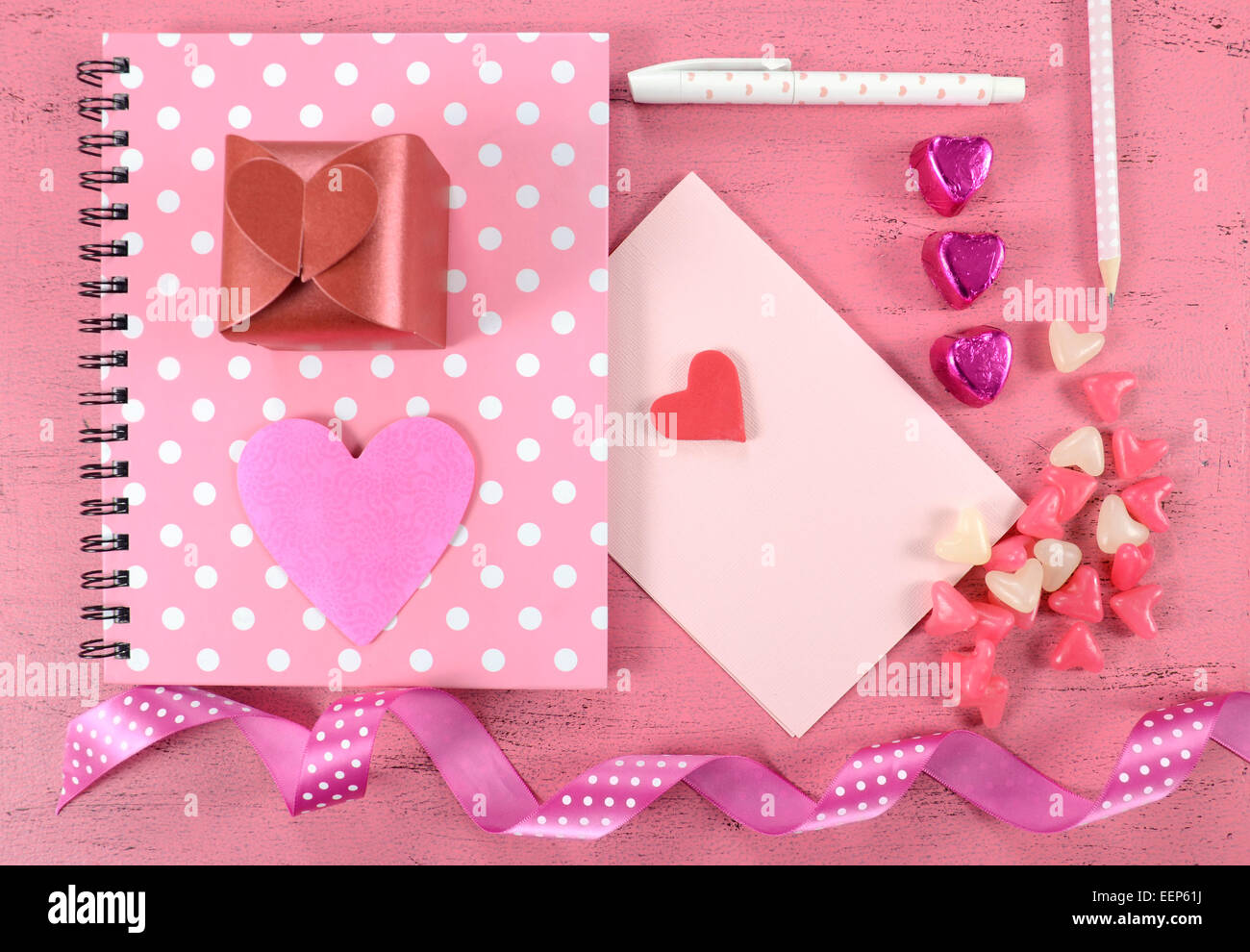 Schreiben Liebesbriefe und Karten für Happy Valentines Day mit Herz Form Süßigkeiten auf rosa shabby chic Holz Hintergrund. Stockfoto