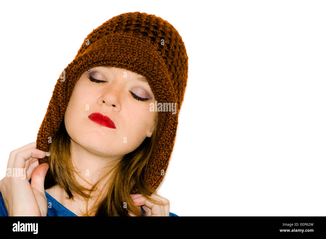 Schöne Frau, die einen Hut Burgund gestrickte ihren Kopf hob leicht nach oben die Augen geschlossener und leuchtender roter lips Stockfoto