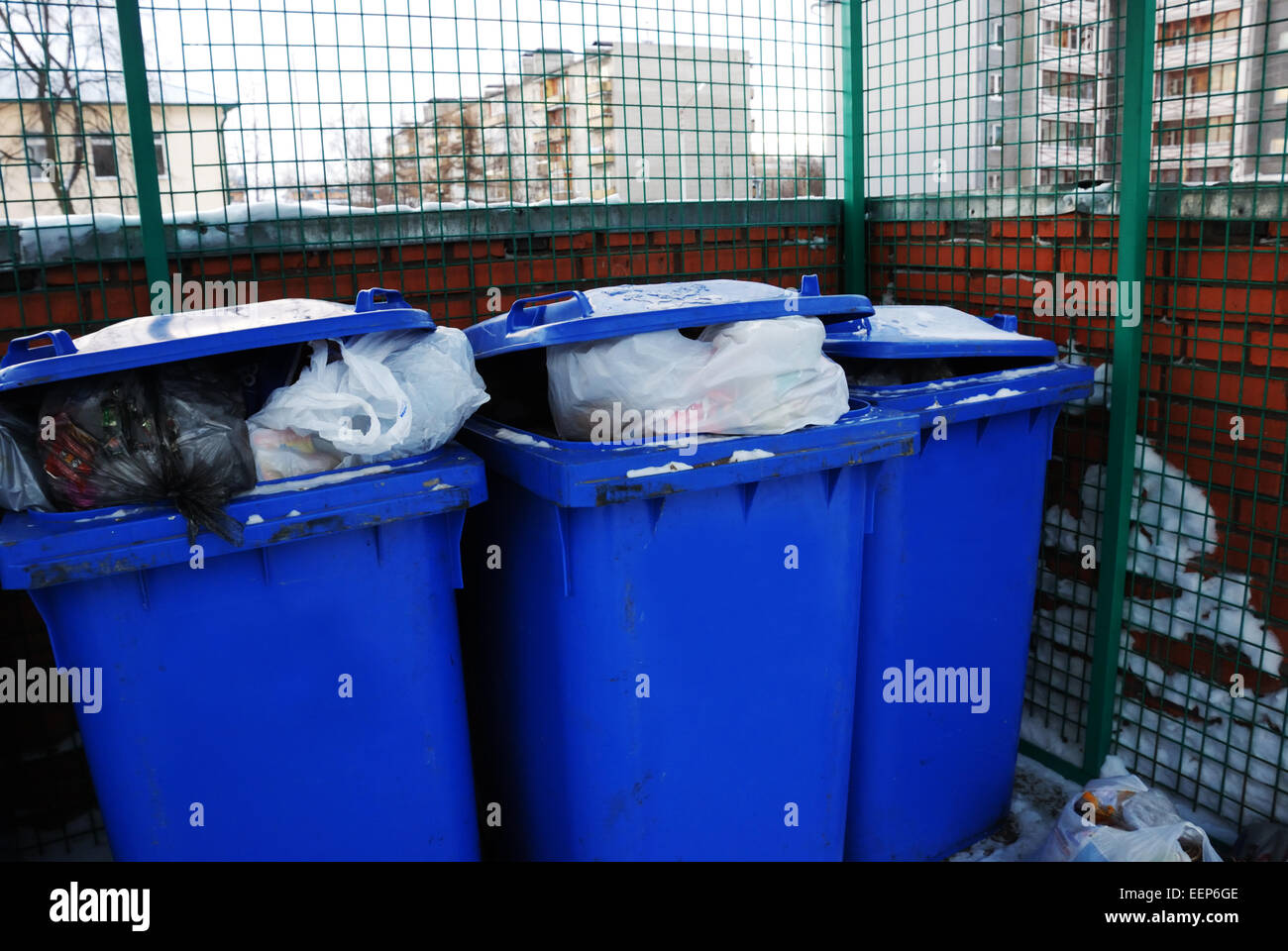 drei blaue Kunststoff Mülleimer im Hof Stockfoto