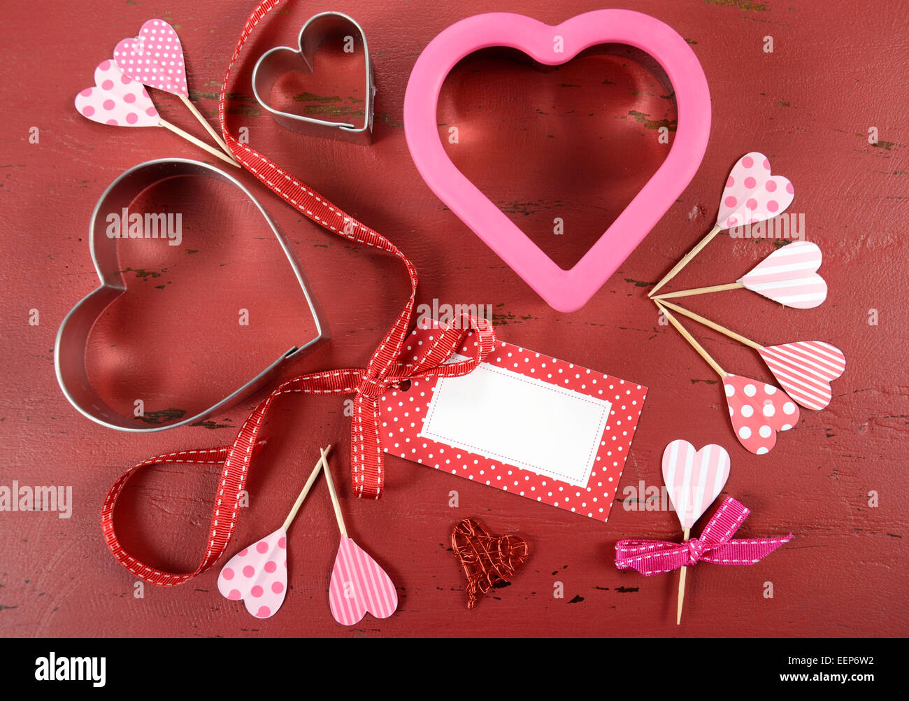 Happy Valentinstag rote Vintage Holz-Hintergrund mit Herz-Form-Ausstechformen und Cupcake Topper mit Geschenkanhänger. Stockfoto