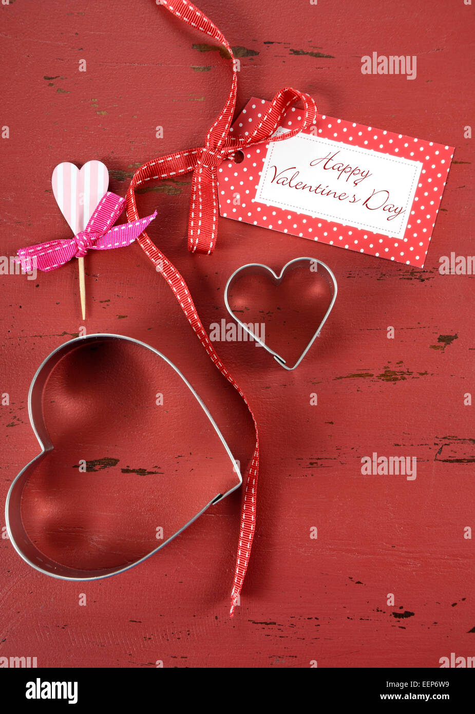 Happy Valentinstag rote Vintage Holz Hintergrund mit Herz-Form-Ausstechformen und Cupcake Topper mit Geschenkanhänger, vertikale Witz Stockfoto