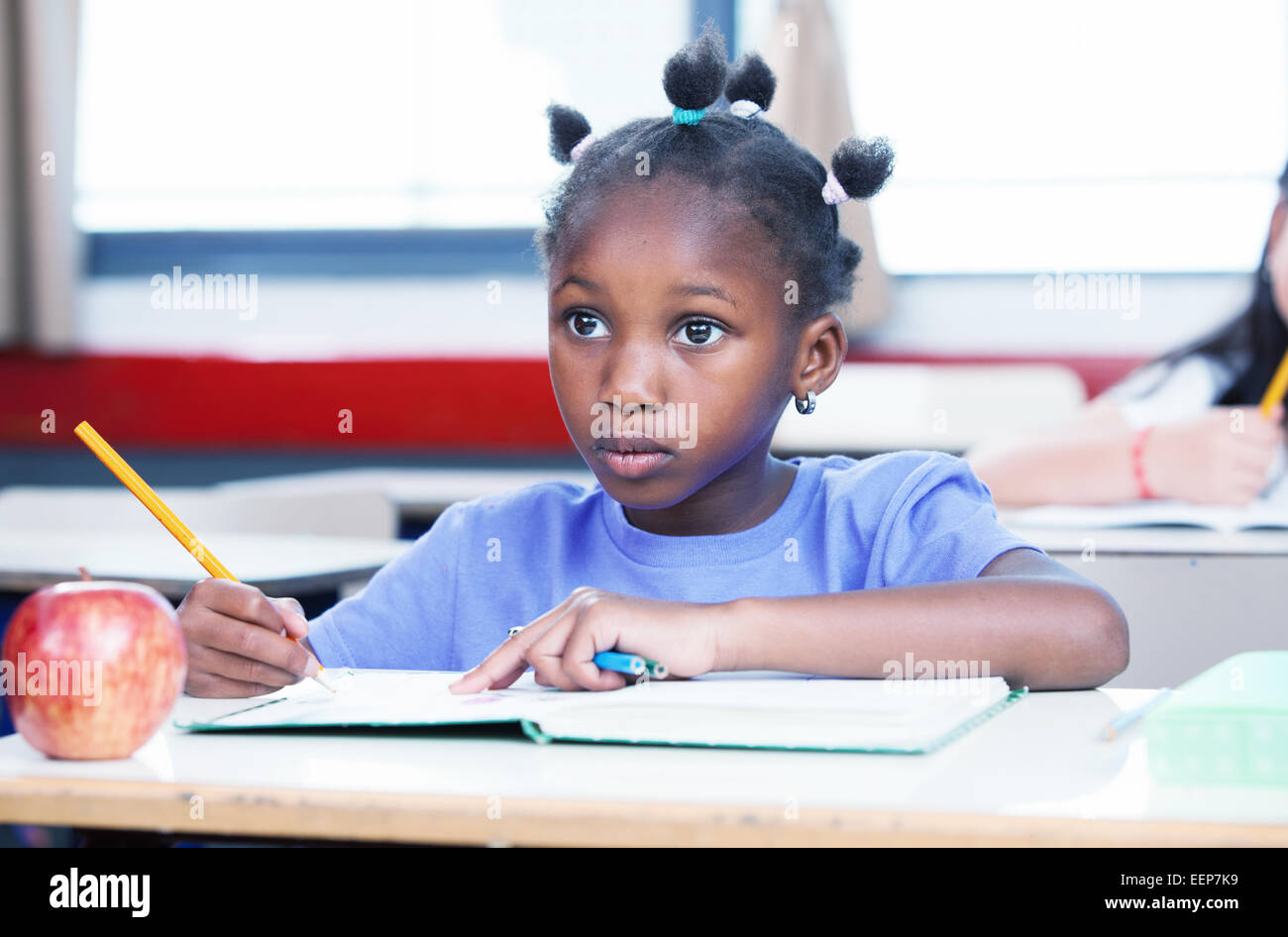 Afro-Amerikanerin in Grundschule Klasse ihr Buch zu schreiben. Stockfoto