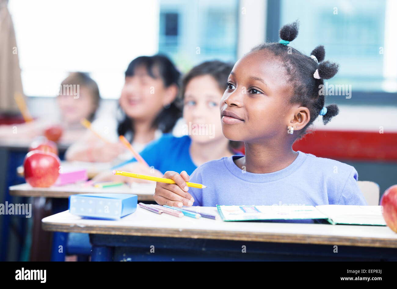 Reihe von Studenten in einem primären interracial Klassenzimmer. Afro Amerikanerin, die Aufmerksamkeit auf den Lehrer. Stockfoto
