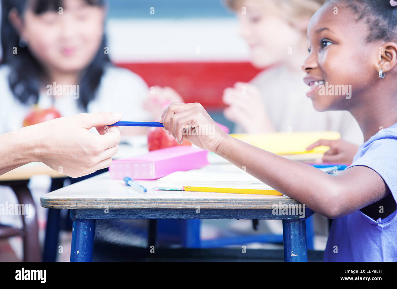Multi-ethnischen Klassenzimmer-Konzept. Kind Übergabe Stift zum Lehrer. Stockfoto