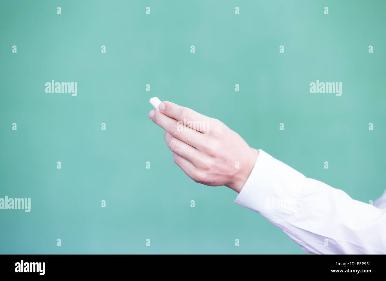 Weibliche Lehrer Hand mit Kreide vor leeren Tafel. Stockfoto
