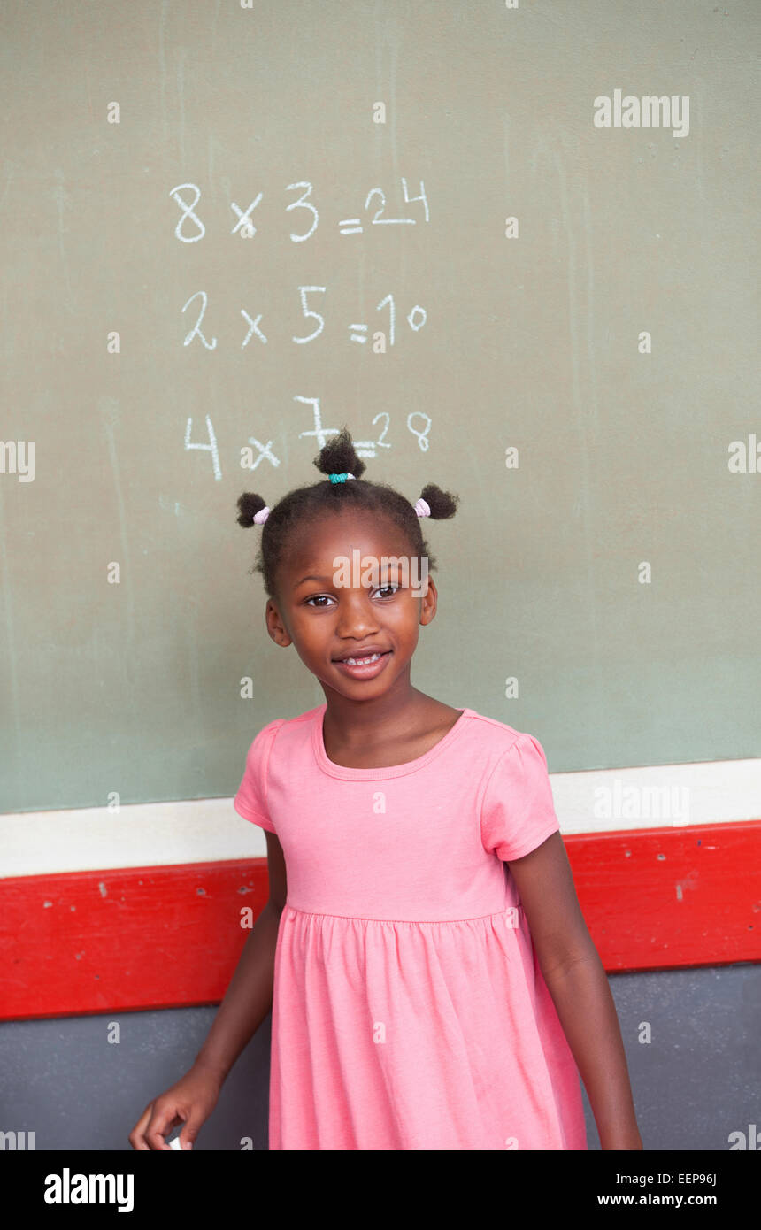 Afro american female Mädchen lächelnd vor Tafel. Schule und Bildung-Konzept. Stockfoto