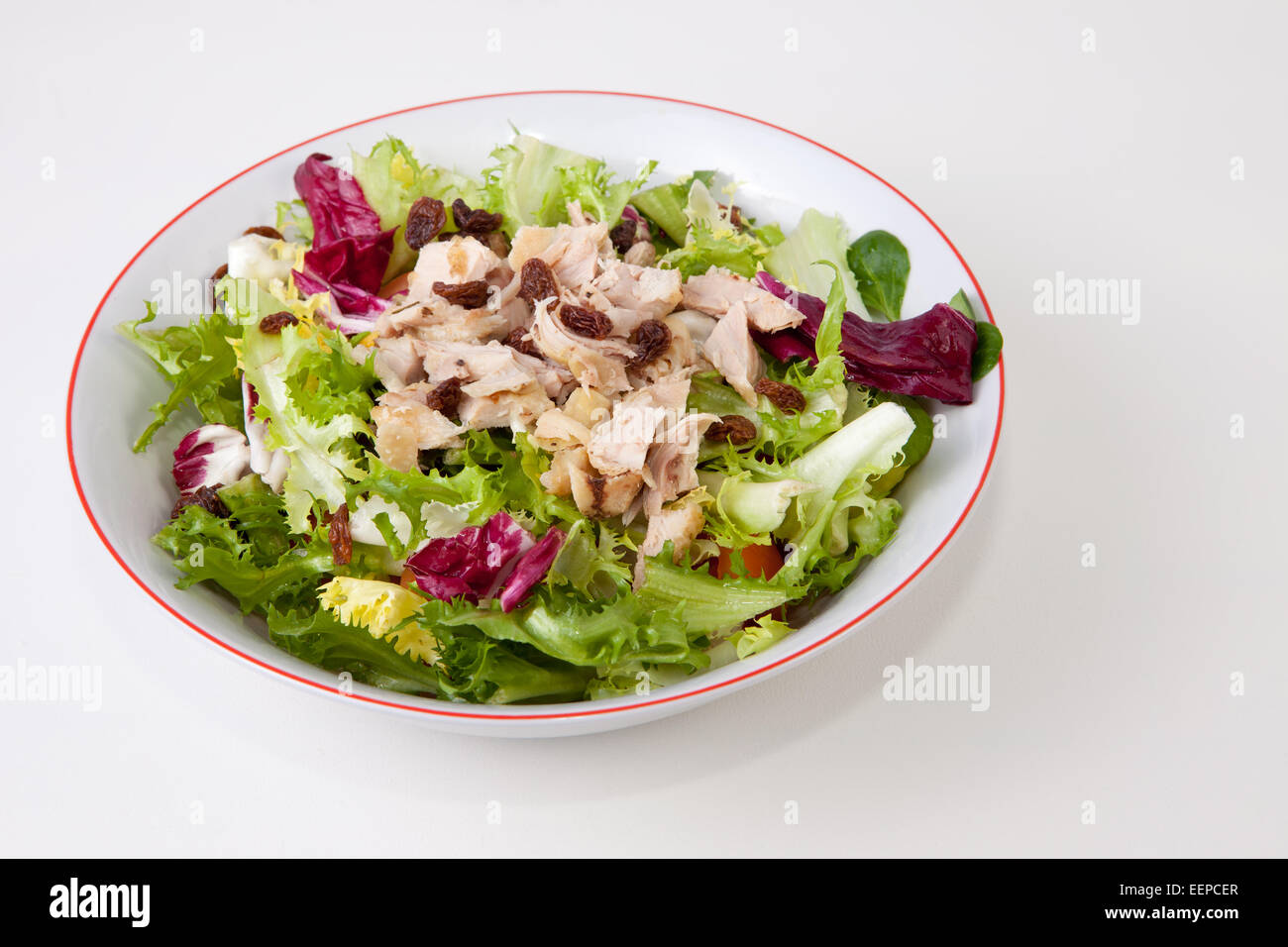 Hähnchen-Salat mit Tomaten und Rosinen in eine Schüssel weiß. Isoliert auf weißem Hintergrund Stockfoto