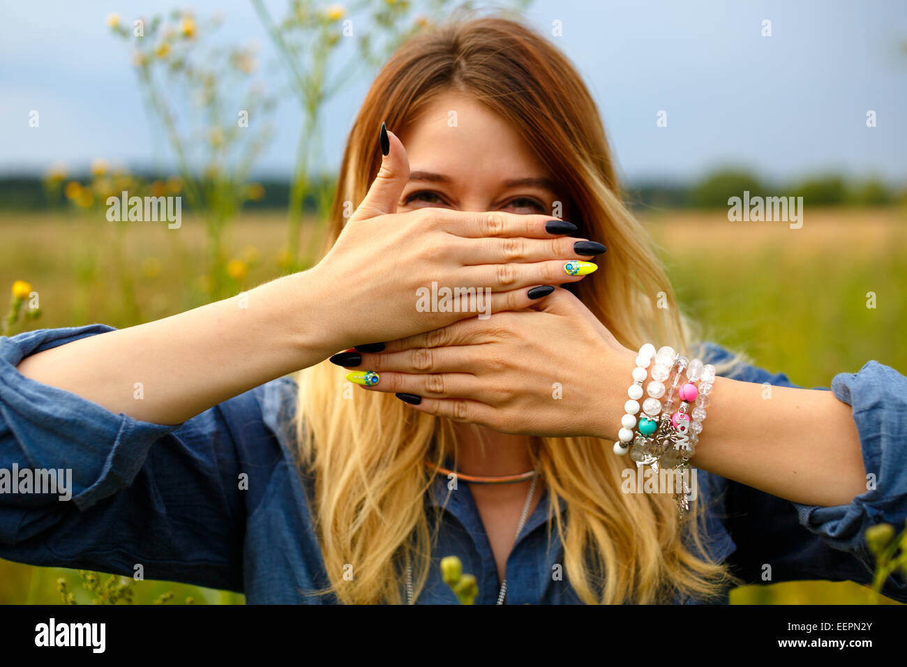 Mädchen bedeckt ihr Gesicht mit den Händen Stockfoto