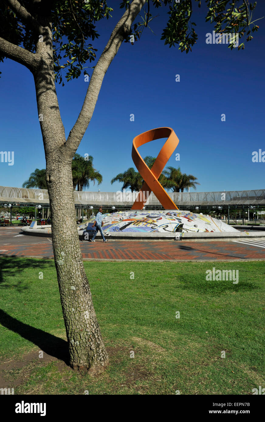 Mann zu Fuß vorbei an Red Ribbon Skulptur auf Mosaik Brunnen Denkmal Gugu Dlamini HIV AIDS-Aktivisten Durban Südafrika Stockfoto