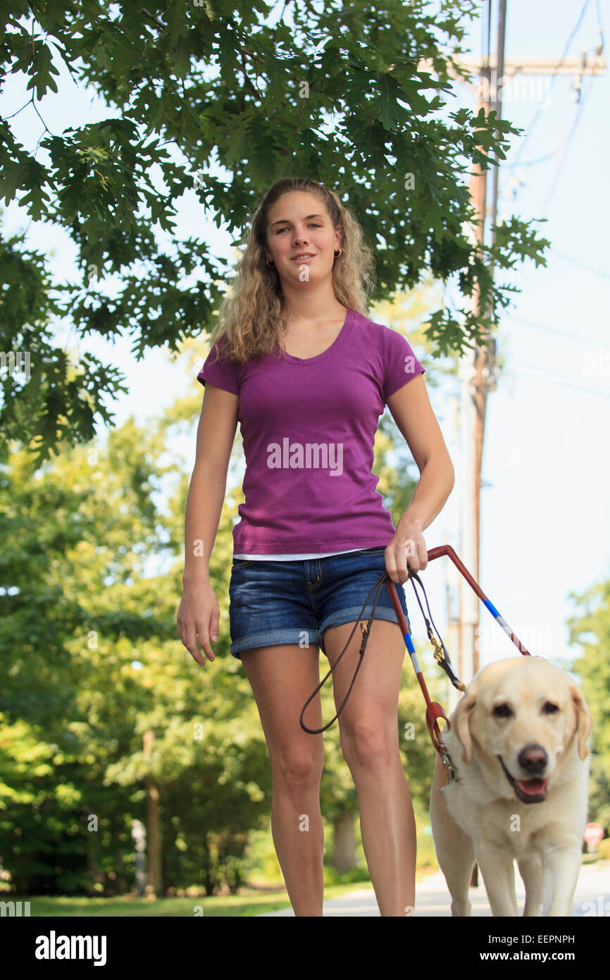 Frau mit Sehbehinderung zu Fuß mit ihrem Servicehund Stockfoto
