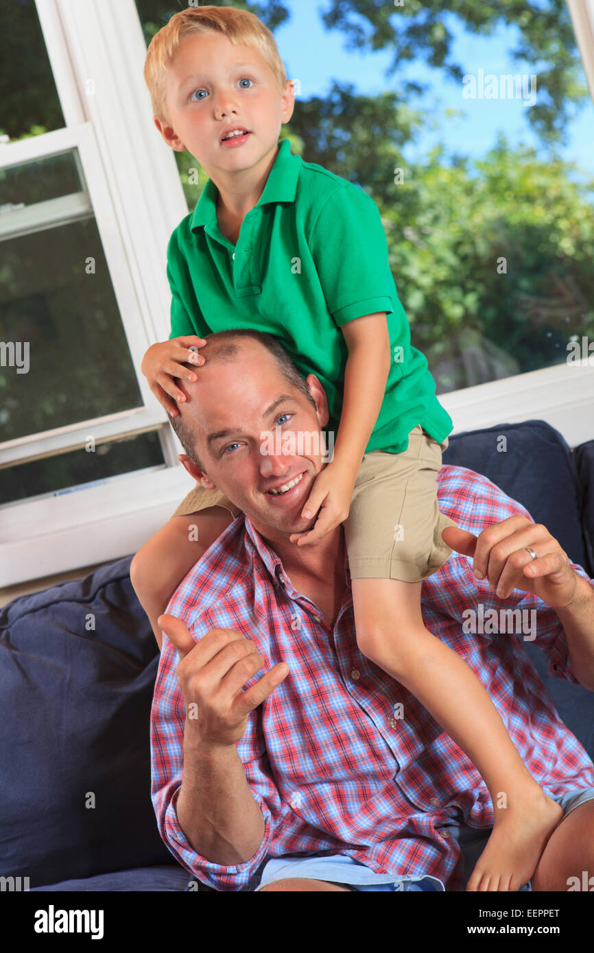 Vater und Sohn mit Hörschädigungen in amerikanischer Gebärdensprache auf ihrer Couch Unterzeichnung "spielen" Stockfoto